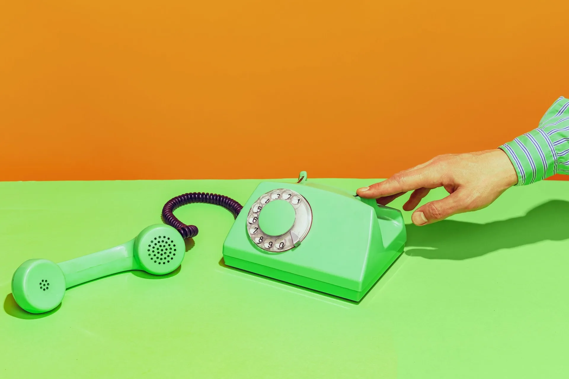 Hand reaching for a rotary phone