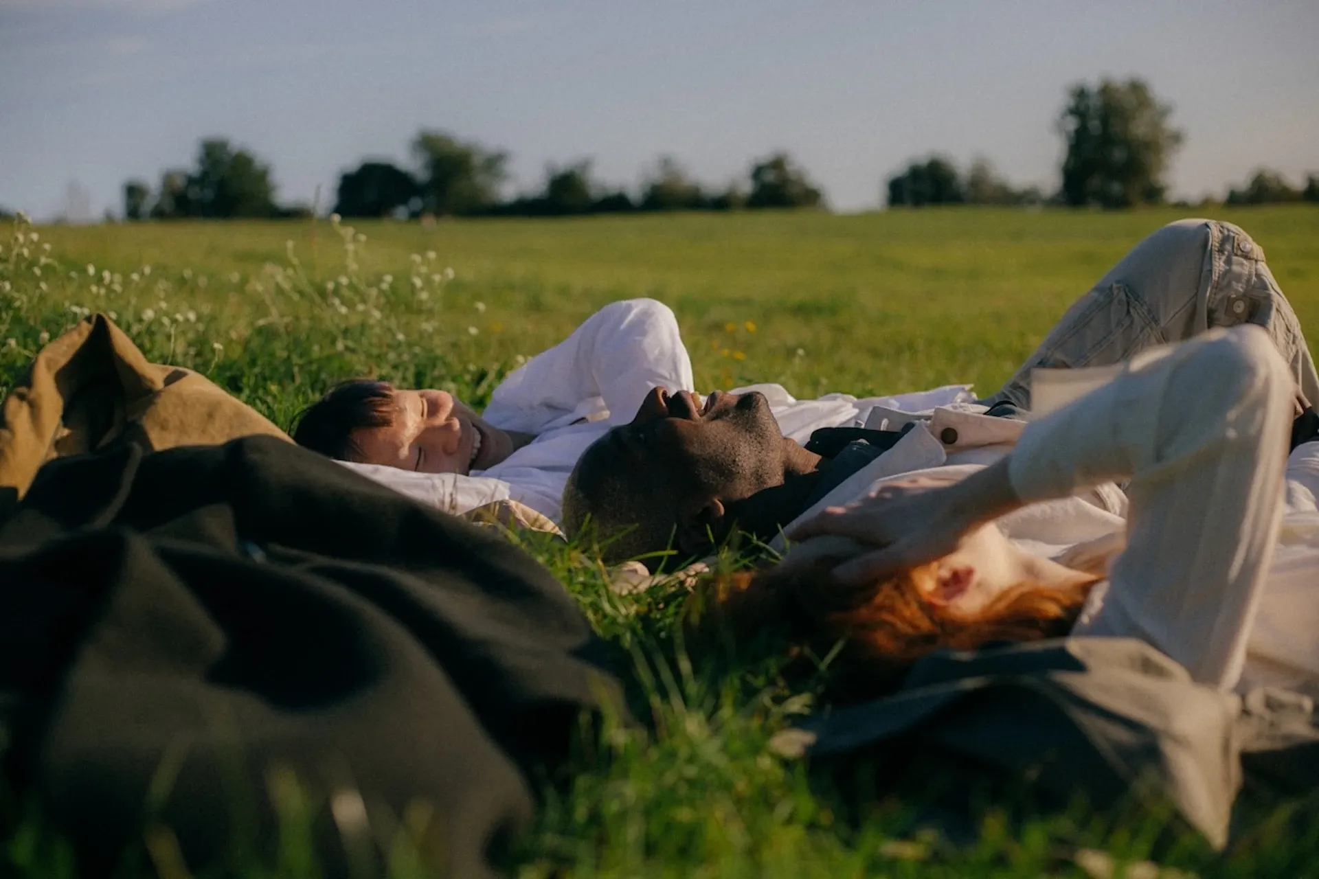 A group of friends layng down in a field together