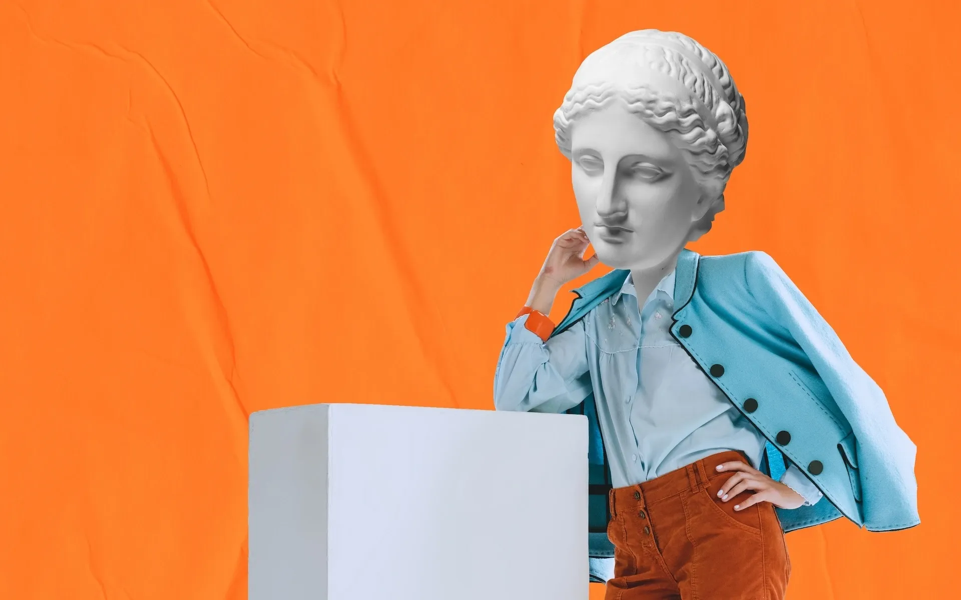 Person wearing a statue head leaning on a plinth